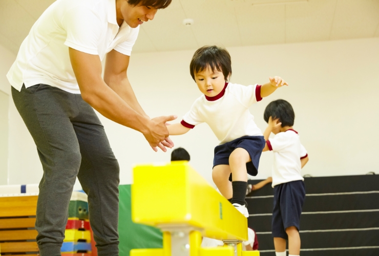 男の子が先生と一緒に跳び箱している写真